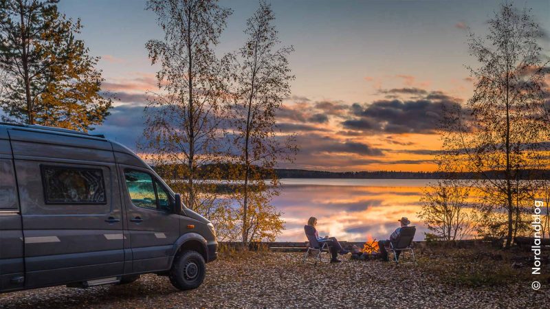 Zwei Camper mit Wohnmobil an einem finnischen See. 