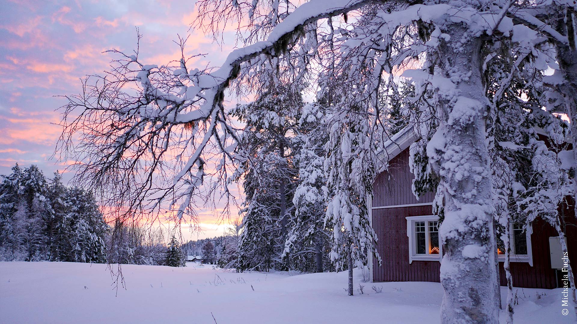 Verschneites Holzhaus in Lappland