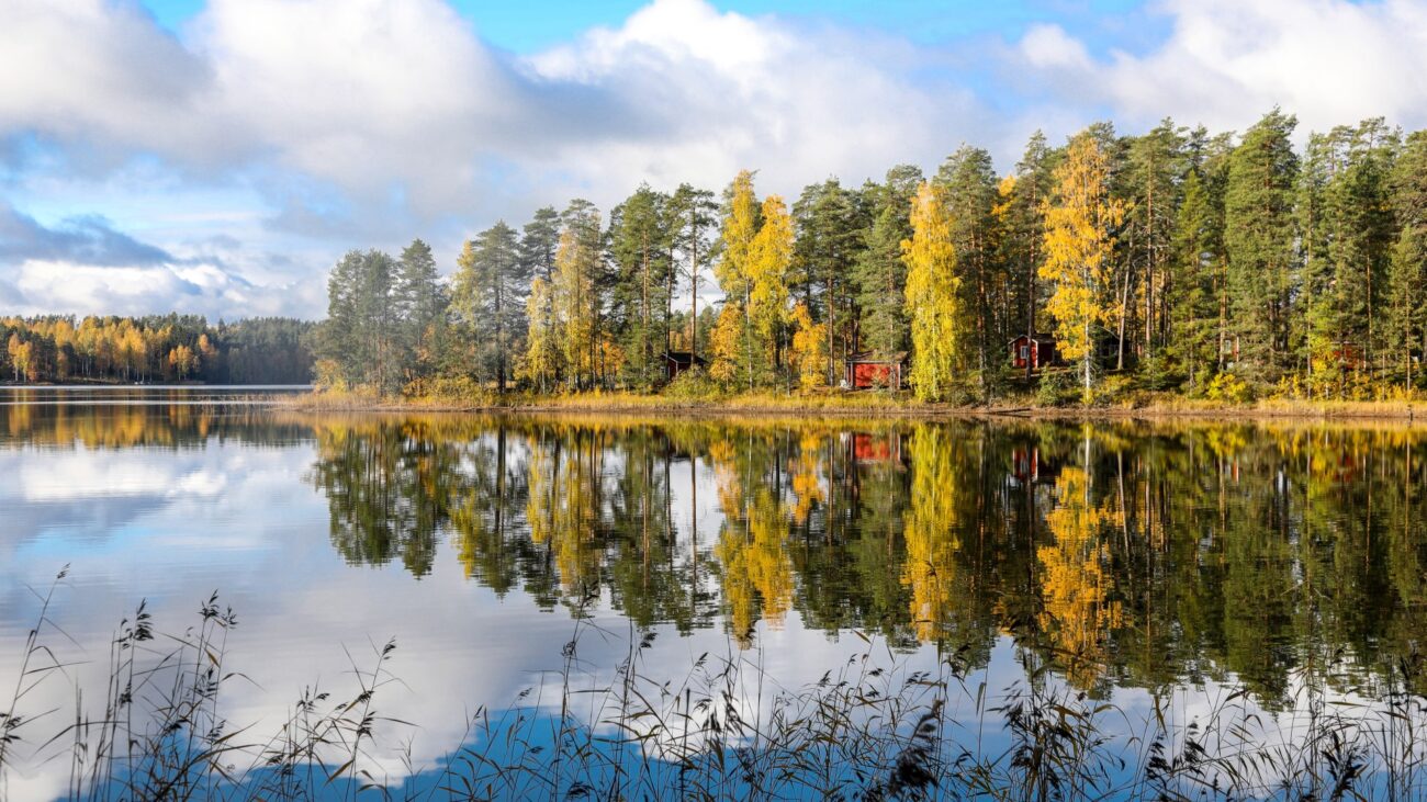 Rotes Holzhaus am See in Finnland.