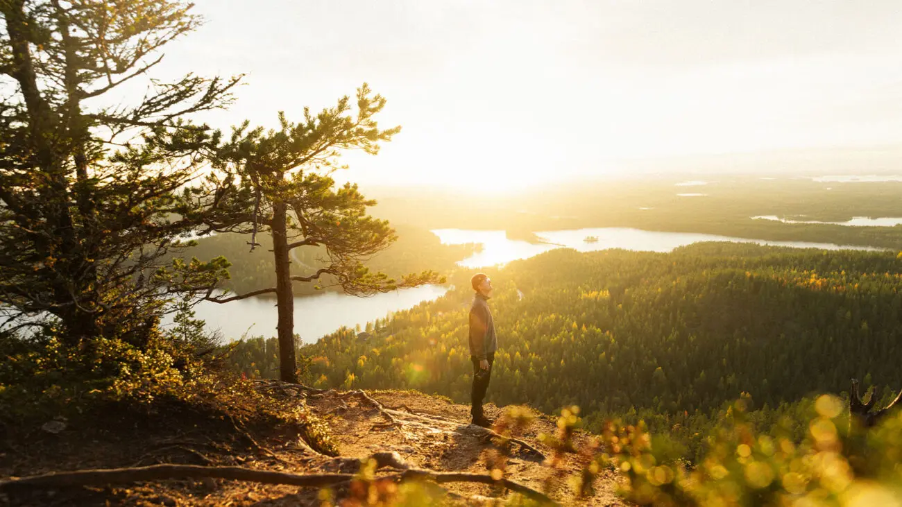 Een man staat op een hoogvlakte en kijkt uit over het landschap van Lapland