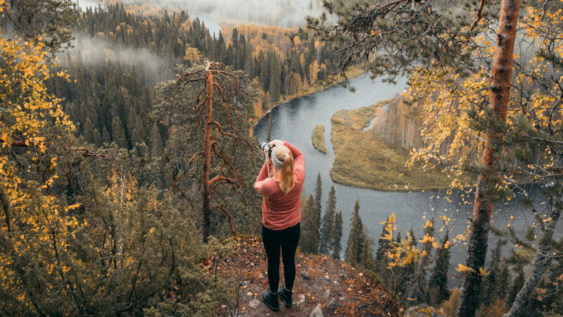 Frau fotografiert spektakuläre finnische Landschaft im Herbst. 