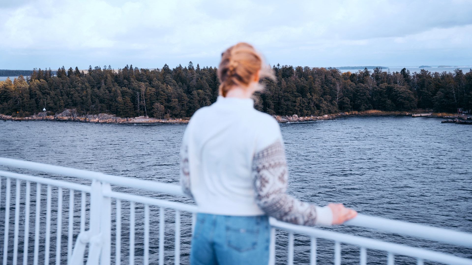 Frau blickt von der Finnlines-Fähre auf die Schäreninseln. 