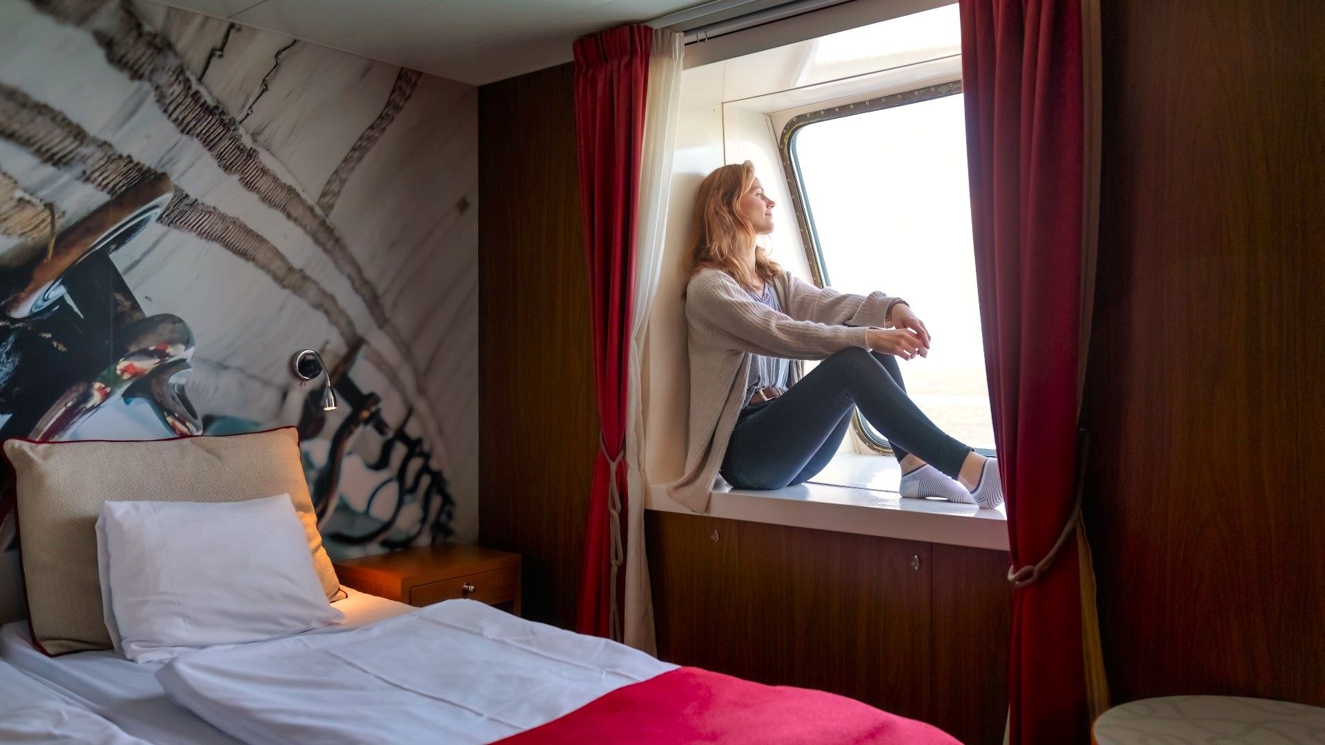 Vrouw zit in de hut en kijkt uit het raam.