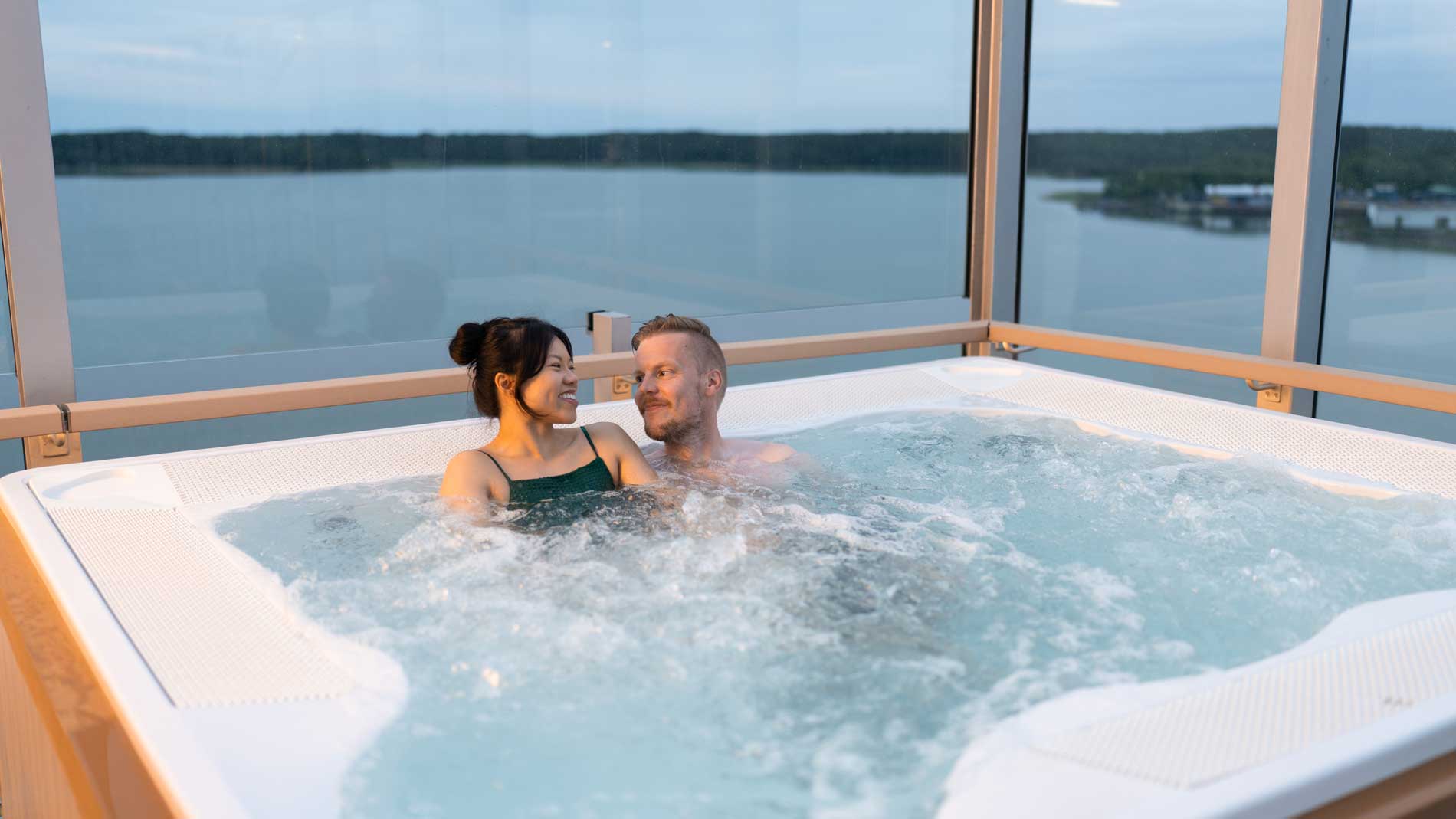Bild på ett par som sitter i bubbelpoolen på utomhusdäck på Finnsirius.