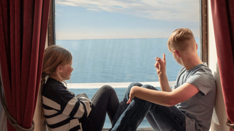 Twee kinderen zitten bij het raam van een Finnlines-hut.