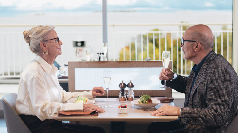 Bild på ett äldre par som sitter på Micke's och äter brunch med varsitt glas bubbel.