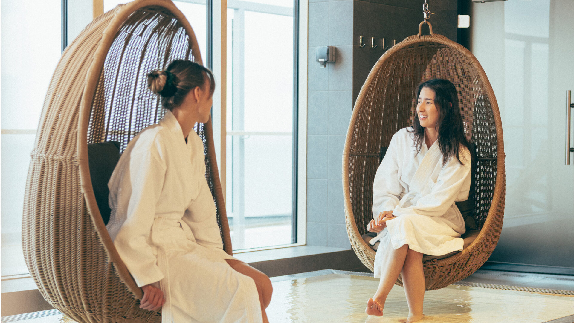 Bild på två tjejer som sitter i varsin vilostol inne på Höyry spa.